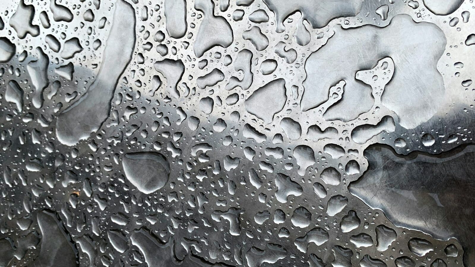 a close up of water droplets on a metal surface