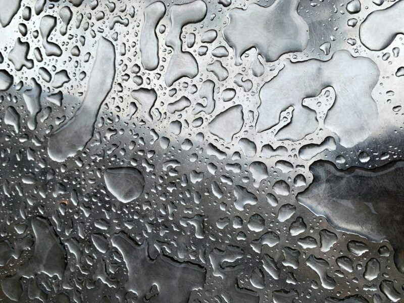 a close up of water droplets on a metal surface