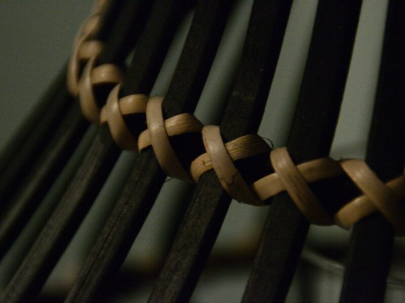 Close-up of woven rattan on dark wooden chair spokes