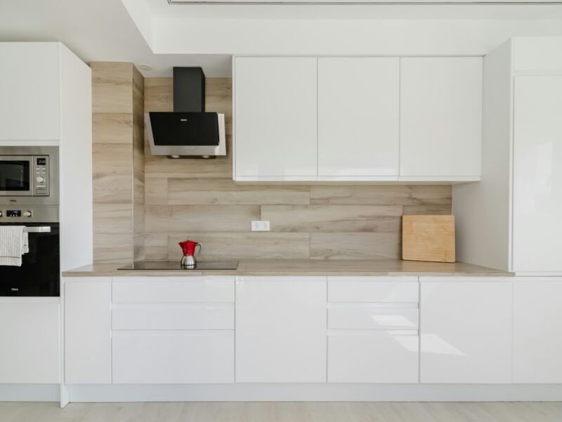 Modern white kitchen with wooden accent wall