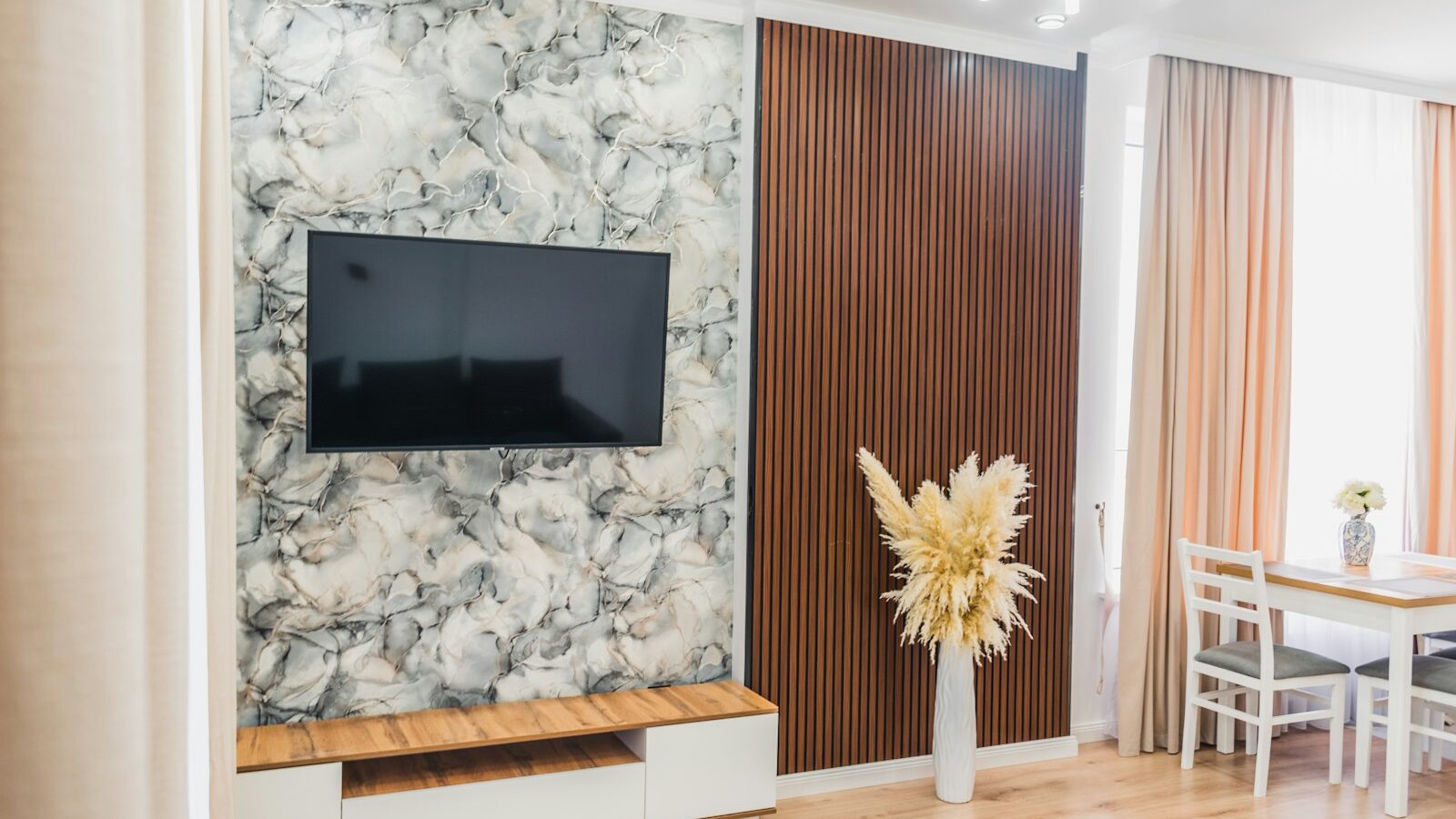 Modern living room with tv, console, and pampas grass decor.