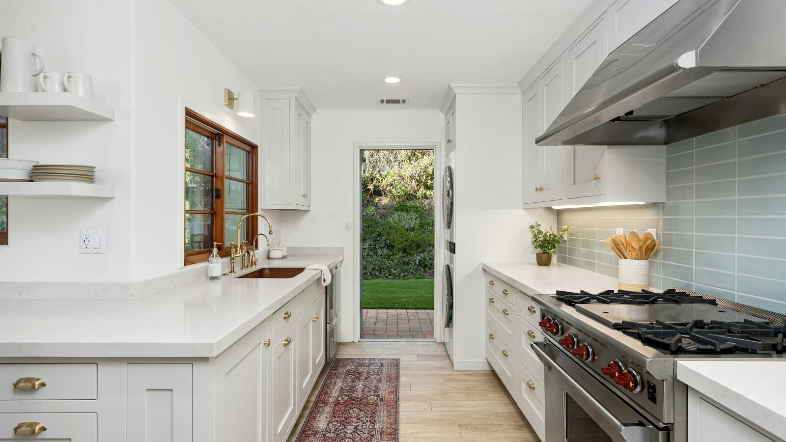 A kitchen with white cabinets and a stove top oven