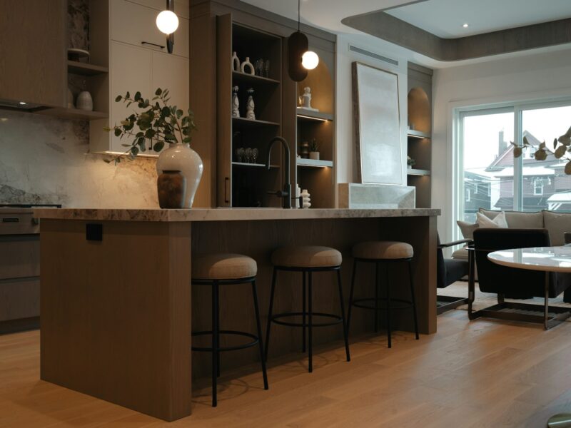 Modern kitchen island with stools and living area view.