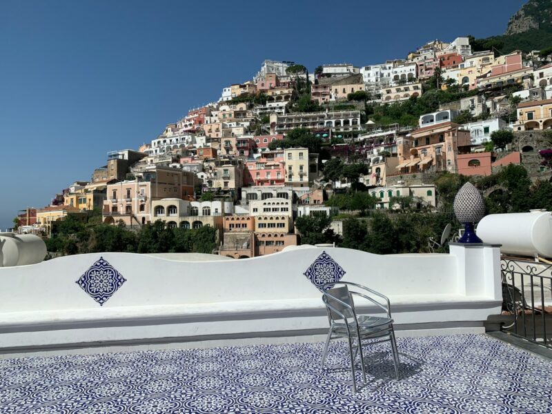 a white wall with a chair and a city in the background